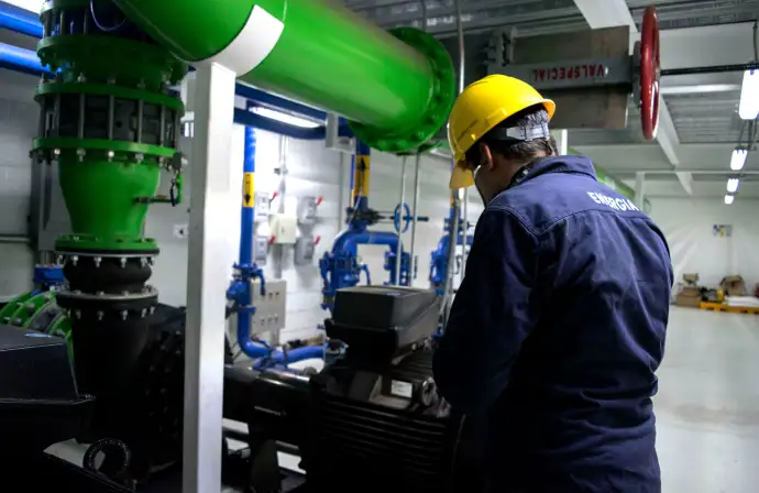 Ingeniero de Tracsa Energía supervisando un sistema de bombeo industrial con tuberías de gran calibr