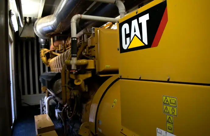 Generador industrial CAT instalado por Tracsa Energía en cuarto de máquinas con ductos de escape y v
